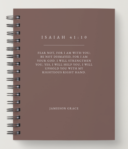 Notebook with Isaiah 41:10 quote on a brown background