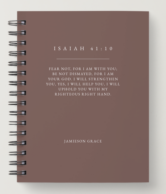 Notebook with Isaiah 41:10 quote on a brown background